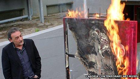 Antonio Manfredi torches a painting by French artist Severine Bourguignon in front of the Casoria Contemporary Art Museum
