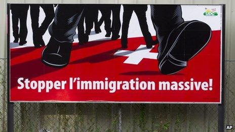 A poster of the right-wing Swiss People's Party (SVP) which shows feet walking on the Swiss cross and the message "Stop mass immigration" (2 Aug 2011)