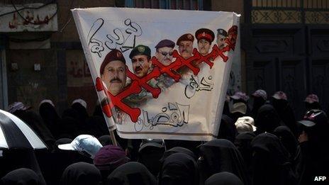 Yemeni women hold a poster demanding the removal of Ali Abdullah Saleh's family from the armed forces (26 April 2012)