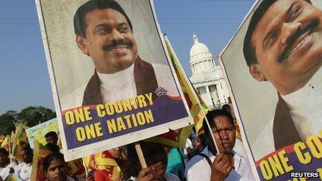 Sri Lankans carry posters of President Mahinda Rajapaksa at a rally opposing the UN Human Rights Council vote against the country - 22 March 2012