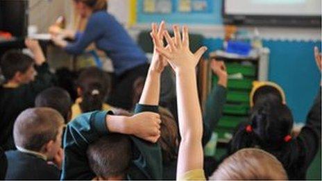 Child's hand raised in classroom