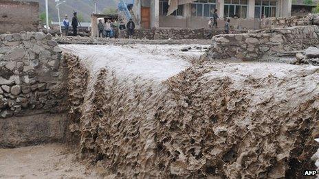 A mudstream washes down through a village in Gansu province, 11 May 2012