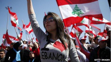 Protesters wave Lebanese flags during a demonstration in Beirut on the anniversary of a popular uprising.