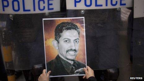 A supporter of Abdulhadi al-Khawaja holds up his picture in front of a line of riot police during a rally in Bahrain's capital Manama in April.