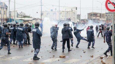 Security forces fire tear gas as they clash with anti-government protesters in Lome