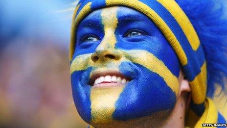A man with the Swedish flag painted on his face