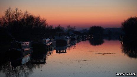 The sun sets over a canal in Slimbridge, England.
