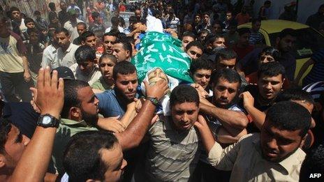 Men carry the body of a Palestinian militant killed in Gaza overnight (23 June 2012)