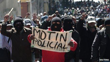 Police officers hold up a sign saying "police mutiny" at a demonstration in la Paz on 24 June 2012