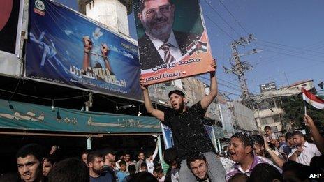 Palestinians celebrate in Rafah town, in the southern Gaza Strip, the victory of the Muslim Brotherhood's presidential candidate Mohamed Morsi (portrait) in Egyptian elections on 24 June 2012