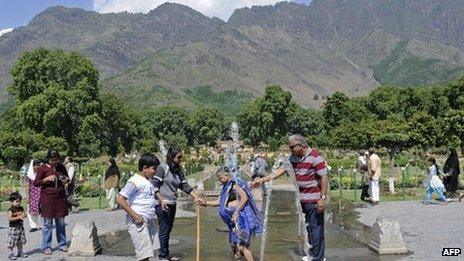 Tourists cool down at a fountain in Kashmir