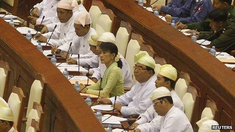 Auung Suu Kyi seated among fellow National League for Democracy members of parliament in Burma's the lower house on 9 July 2012