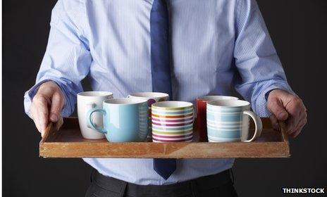 Man carrying tray with mugs