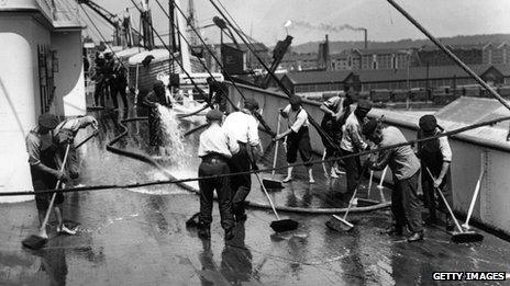 men scrubbing the deck