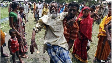 Jahar (C), a 105-year-old villager affected by ethnic riots, is carried by his son to a relief camp near Bijni town in the northeastern Indian state of Assam July 26, 2012