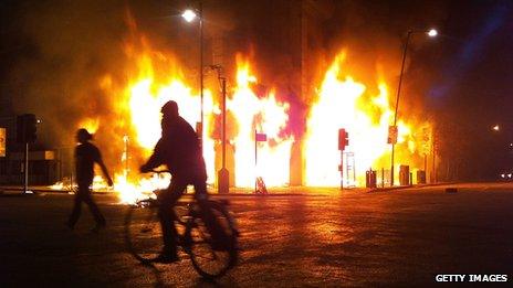 A Carpetright store burns on Tottenham High Road, in London, after being set on fire by rioters on 6 August 2011