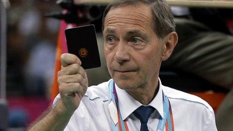 A referee issues a black card in badminton