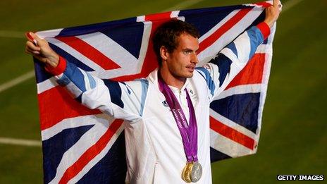 Andy Murray wearing a gold medal and holding up Union Jack flag