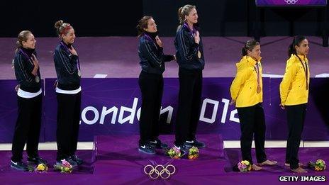 Medal winners of beach volleyball stand on podium