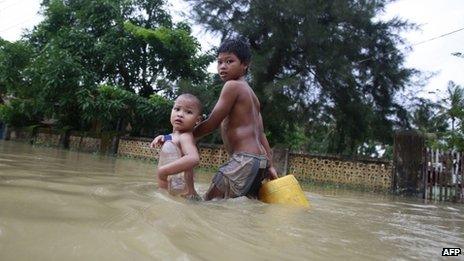 Children walking through flood water in Pathein, in the Irrawaddy delta region of Burma, 21 August 2012