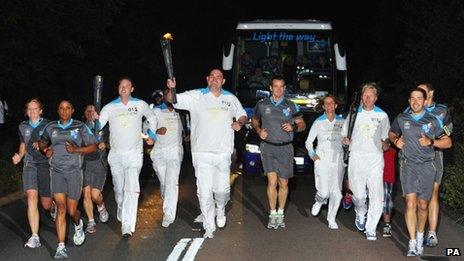 A torchbearing team carries the Paralympic Flame on the Torch Relay leg between Aylesbury and Weston Turville