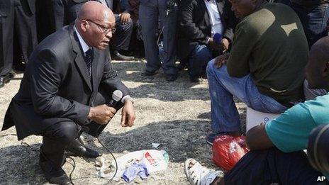 South Africa"s President Jacob Zuma, left, interacts with striking mine workers at the Lonmin mine near Rustenburg, South Africa, Wednesday, Aug. 22, 2012.