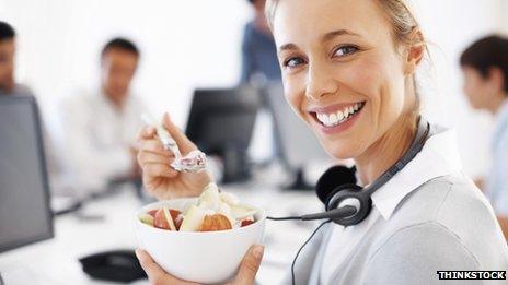 Woman eating food at her desk