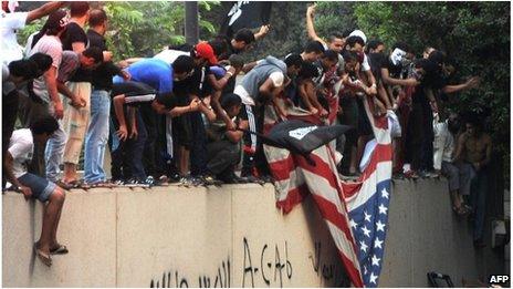 Protesters tear down a US flag at the US embassy in Cairo, Egypt (11 Sept 2012)