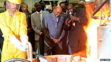 Sudan's President Omar al-Bashir (C) smiles as he looks on at the process of gold refining during the inauguration of the Sudan Gold Refinery in Khartoum, 19 September 2012