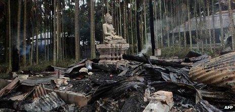 A statue of Buddha is left standing amidst the torched ruins of the Lal Ching Buddhist temple at Ramu on September 30