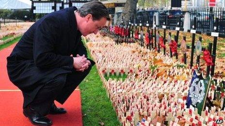 David Cameron pictured in 2009 looking at commemorative crosses