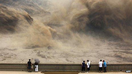 Visitors gathering to giant gushes of water released from the Xiaolangdi dam to clear up the sediment-laden Yellow river and to prevent localized flooding