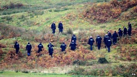 A police team search land near Machynlleth