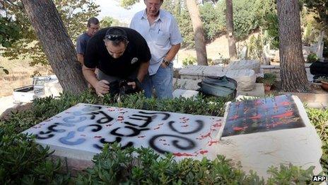 Men inspect the damage done to Moshe Dayan's grave (16 October 2012)