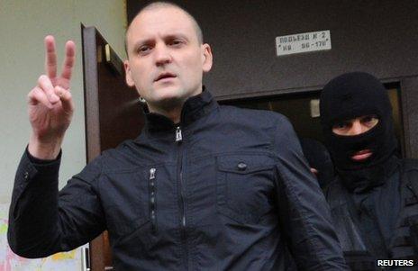 Sergei Udaltsov flashes a victory sign as he is led away in Moscow, 17 October