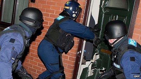 Police officers raid a house in Manchester