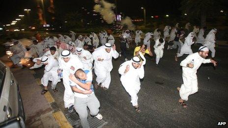 Kuwaiti protesters run for cover in Kuwait City, 21 October 2012