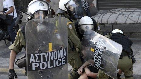 Greek police detain a demonstrator in Athens during the 24hr strike on 18 October 2012