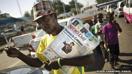 A man holding a newspaper, in Zimbabwe