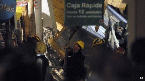 Rescuers work amid debris inside a supermarket where the roof collapsed in Neuquen