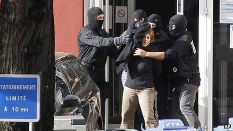 Izaskun Lesaka, centre, surrounded by French Police officers, reacts as she leaves the hotel where she was arrested in the early hours of October 28