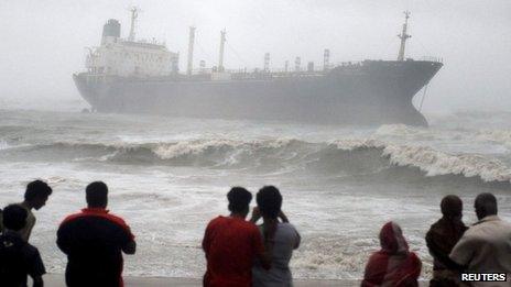 Onlookers watch ship Pratibha Cauvery, which ran aground allegedly due to strong winds, on the bay of Bengal coast, in the southern Indian city of Chennai, October 31, 2012