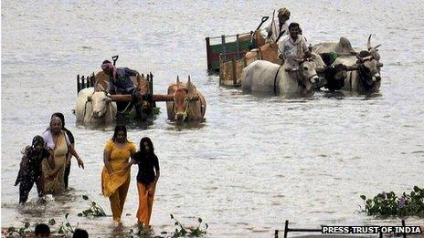 A family crosses a lake to take shelter in a safer place as cyclone Nilam threatens to hit Nellore district of Andhra Pradesh.