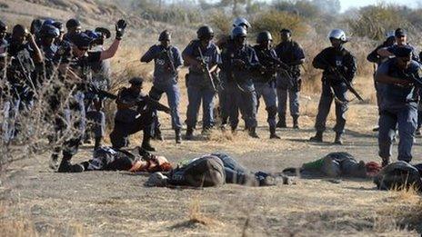 police aiming at miners laying on the ground after police opened fire during clashes near the Marikana platinum mine