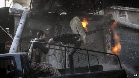 A rebel fighter fires a gun towards government forces in Aleppo, Syria (4 November 2012)