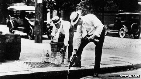 Men pour liquor down a drain in 1920