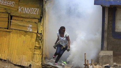 A woman flees from tear gas fired by police in Eastleigh (19 November 2012)