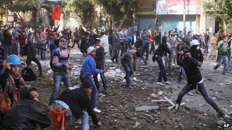 Egyptian protesters throw stones at Egyptian riot police, unseen, in Tahrir Square in Cairo, Egypt, Monday, 21 Nov 2011