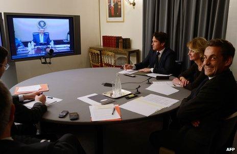 Nicolas Sarkozy (right), then French president, smiles at the Elysee Palace during a video link-up with his US counterpart, Barack Obama, 12 April 2012