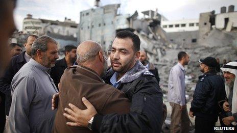 A Hamas police officer is hugged by a Palestinian man after they returned to their destroyed police headquarters in Gaza City